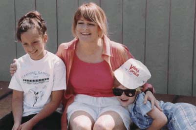 Mackenzie Rosman, Susan Skelly and her son Micheal Skelly sitting on a chair at the 2002 Carousel Ranch Walk - Jog and Roll-A-Thon