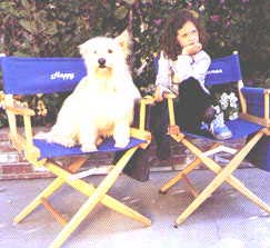 Mackenzie and her companion, Happy, sitting on their on-set chairs during rehearsals